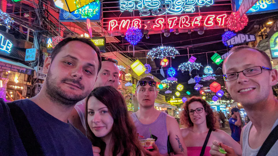 Peter Zošiak a jeho přátelé si užívají večer na slavné Pub Street v Kambodži. Neonové cedule, zavěšené lampiony a živá atmosféra ulice plné barů a restaurací.